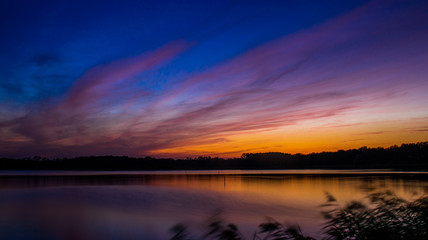 Widok zachodzącego słońca nad stawem w Dolinie Baryczy