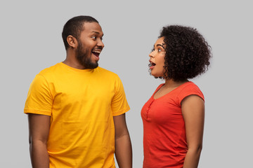 relationships and people concept - happy excited african american couple over grey background