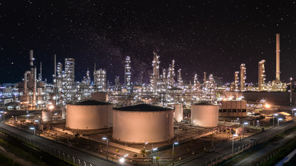 Oil and gas refinery plant and storage tank form industry zone at night sky with star, Aerial view...
