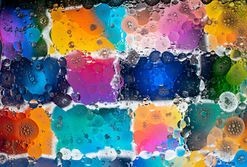 Graphic resource for a background of colored tiles with the effect of water and oil blurring.