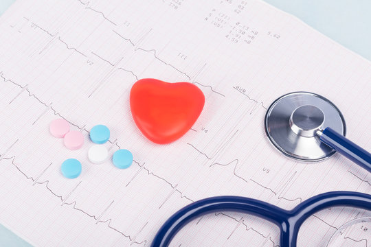 a stethoscope and a red heart lie on the conclusion of an electrocardiogram - Powered by Adobe
