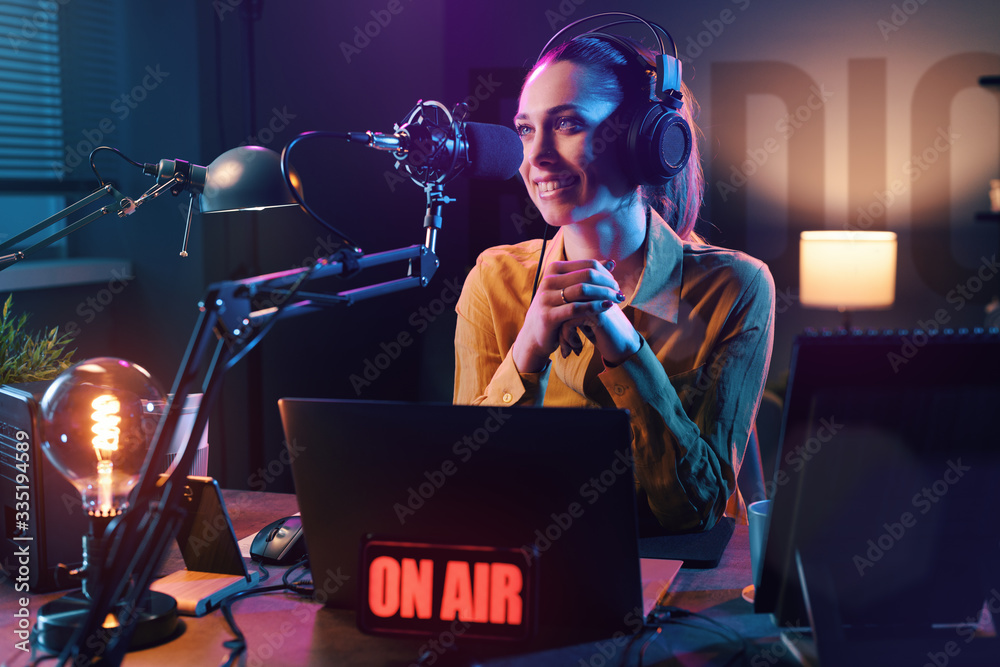 Wall mural Young radio host broadcasting in the studio