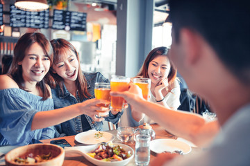 happy young group dining and drinking beer at restaurant