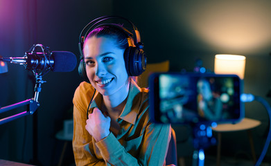 Smiling video blogger recording in the studio