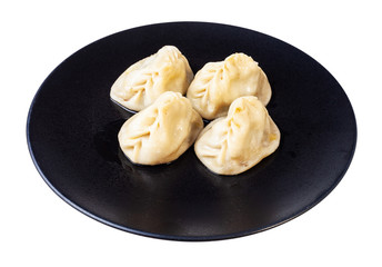 portion of cooked Manti on black plate isolated