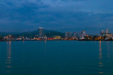 Fototapeta premium Batumi, Adjara, Georgia. View from the sea on illuminated resort town at evening