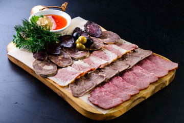 Set mix jerky, sausage, salami and bacon served on a wooden board