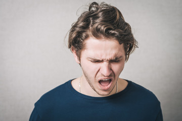 The man screams, despair, grief. Gray background