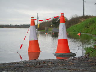 Red warning cone in water, concept nature disaster flood.