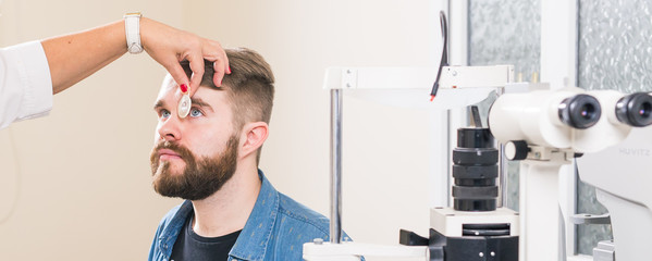 Medicine, health, ophthalmology concept - Ophthalmologist examines patient's eyes.