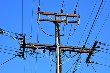 Power grid intersection on concrete pole with isolators and wires coming from four sides.
