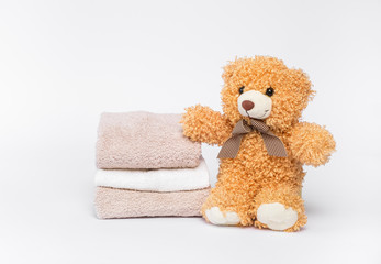 Teddy bear and a stack of clean and fresh cotton towels