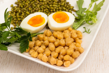 Chickpeas, mung bean, egg and greens on white