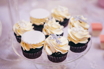 Cupcakes with cream and silver cross on top