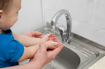 Wash baby's hands under running water