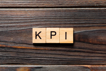 kpi word written on wood block. kpi text on table, concept