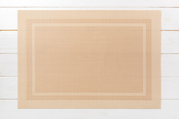 Top view of brown place mat for a dish. Wooden background with empty space for your design