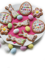 Fototapeta na wymiar Homemade Easter cookies in shape of bunny and Easter eggs on a plate on white background. Springtime background on selective focus 