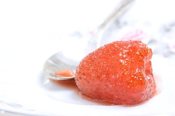Red strawberry on the background of a teaspoon