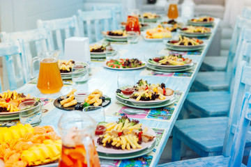 Festive table with food for children. Blue interior