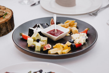 Black plate in a restaurant with cheese