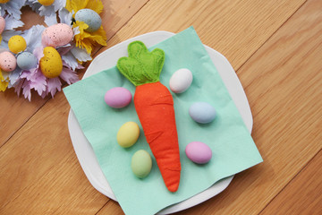 Carrot made by felt with Easter decorations on wooden table. Easter background

