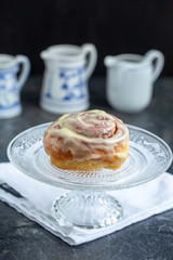 Glazed homemade cinnamon buns on a dark table, dark background, copy space, top view.