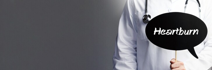 Heartburn. Doctor in smock holds up speech bubble. The word Heartburn is in the sign. Symbol of...