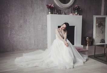 Beautiful bride in wedding dress with lace. Studio interior.