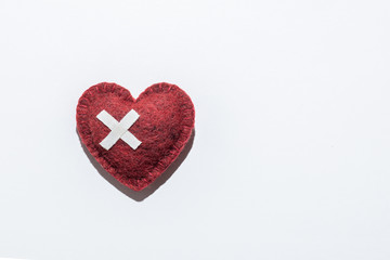 red textured heart on a white background, bandaged, medical background, concept of help and saving lives