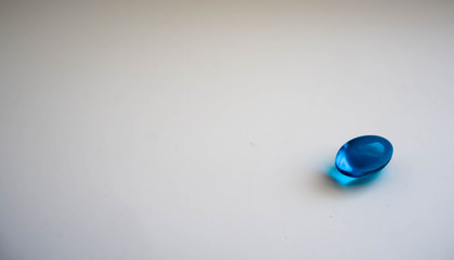 Oval blue pill on a gray background