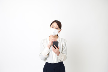 マスクをしてスマートフォンを持っている女性