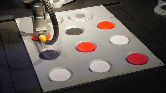 Robot put red marker in line and win tic-tac-toe game, move arm over full diagonal. Interactive recreation for children at science exposition, industrial articulated manipulator used to place disc
