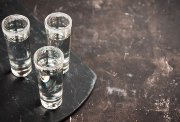 Tequila shots on the dark rustic background. Selective focus. Shallow depth of field.