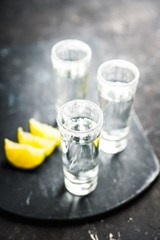 Tequila shots on the dark rustic background. Selective focus. Shallow depth of field.