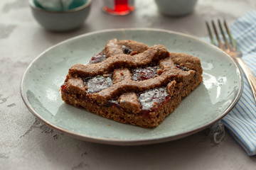 Beautiful homemade austrian Linzer cake cookies or Schnitte in german on beautiful rustic plate. Natural light, selective focus.