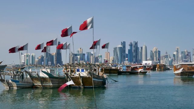 Traditional Dhow, Arab sailing vessels with Qatar flags in the harbour with the Doha skyline in the background