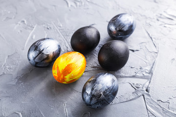 Holidays, design and modern easter concept - Black and brown easter eggs style minimalism on grey background.