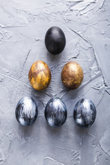 Holidays, design and modern easter concept - Black and brown easter eggs style minimalism on grey background.