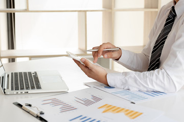 A business man is sitting at a desk and calculating financial graphs about real estate investment expenditures