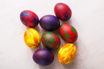 Holidays, traditions and Easter concept - Multi-colored decorative colourful eggs on white background. Top view.