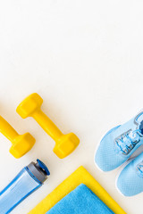 workout accessories. Sneakers, dumbbells, towel on white background top view copy space