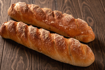 Fresh and tasty french baguette with a crispy crust on a wooden table