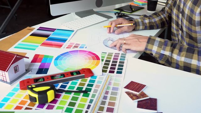 4k video of Interior designer or engineer hand working with equipment architects with modern computer on desk with sample material board and Planning Blueprint.