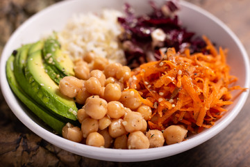 Chickpeas and white rice bowl with carrots and red radish and oily seeds. Complete vegan dish, vegan poke bowl. 