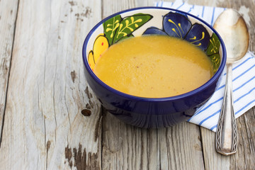 Turkish red lentil soup - with silver spoon on wooden table. Natural light. Selective focus.