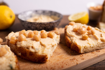 Fototapeta na wymiar Homemade bruschetta with hummus and boiled chickpeas. Delicious and healthy snack or appetizer.