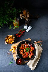 Rustic chicken wings in honey with potato wedges