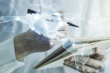 Double exposure of abstract digital world map with connections and man hand writing in notepad on background, big data and blockchain concept