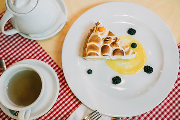 Sweet cake served on the plate with a lemon jam and berries